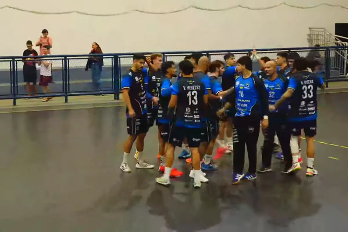 Jogadores de handebol disputando a bola em uma partida tensa entre Taubaté e Cascavel.