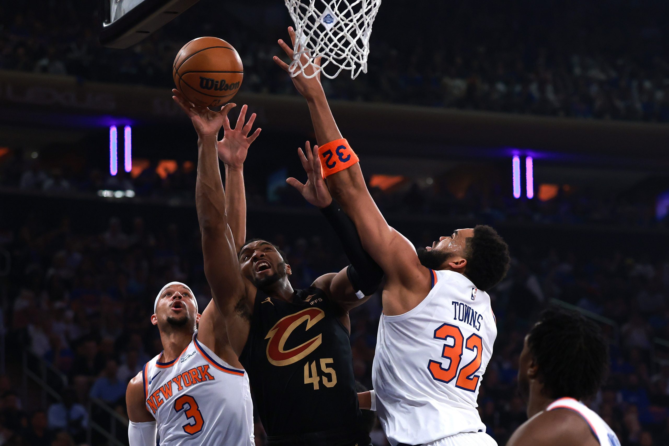 Jalen Brunson (Knicks) driblando a bola enquanto é marcado por Donovan Mitchell (Cavaliers) em quadra.