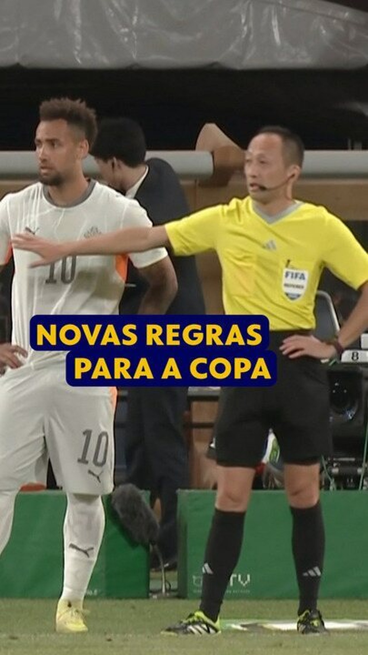 Árbitro em campo durante uma partida de futebol, supervisionando o jogo.