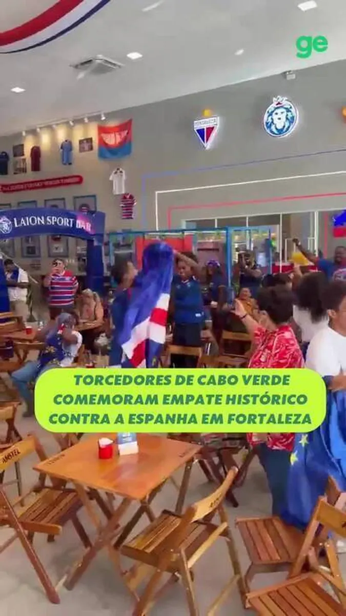 Torcedores de Cabo Verde comemoram um gol vestindo as cores de sua seleção em um ambiente festivo em Fortaleza.