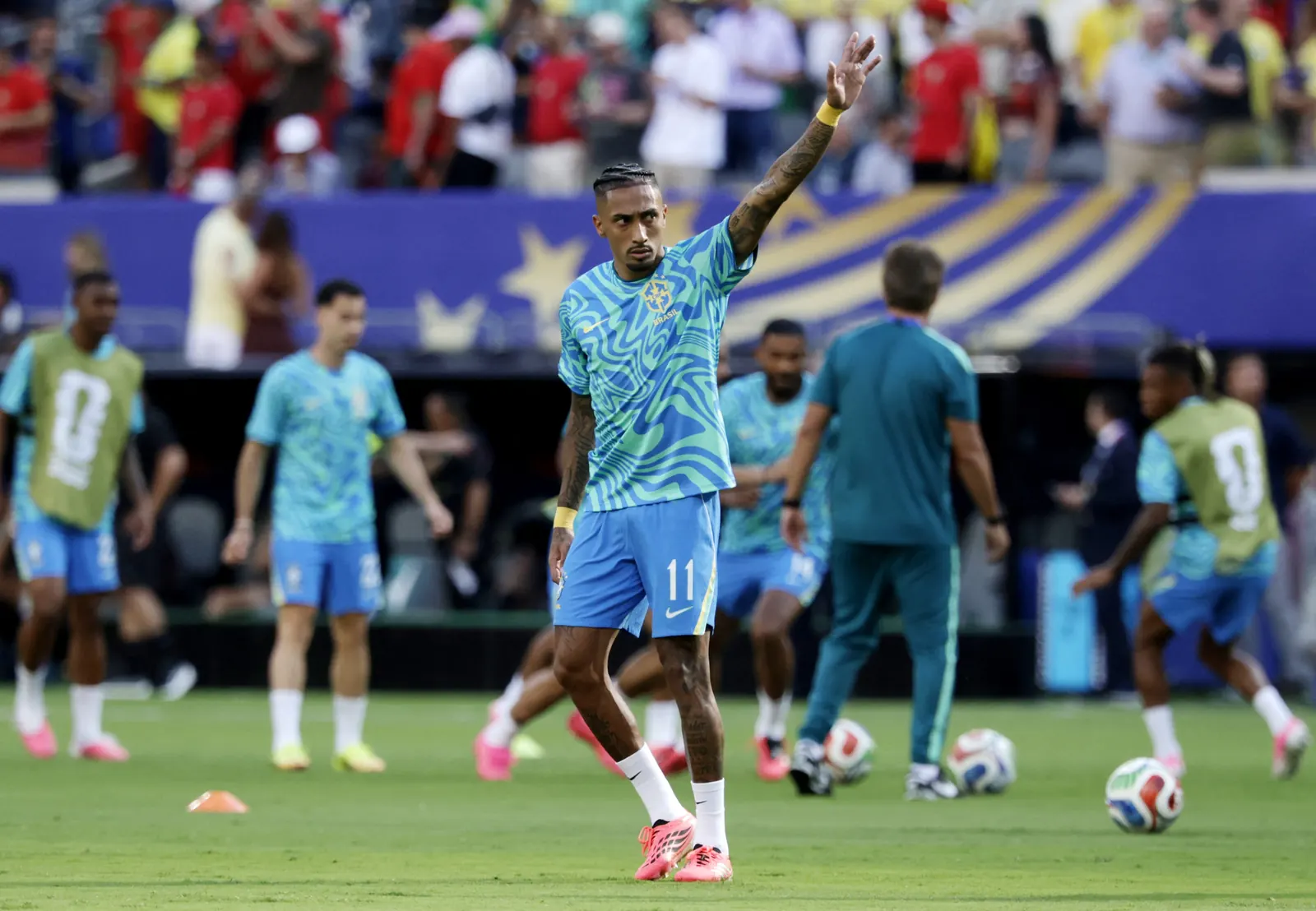 Jogador Raphinha em campo com a camisa da Seleção Brasileira durante partida da Copa do Mundo.