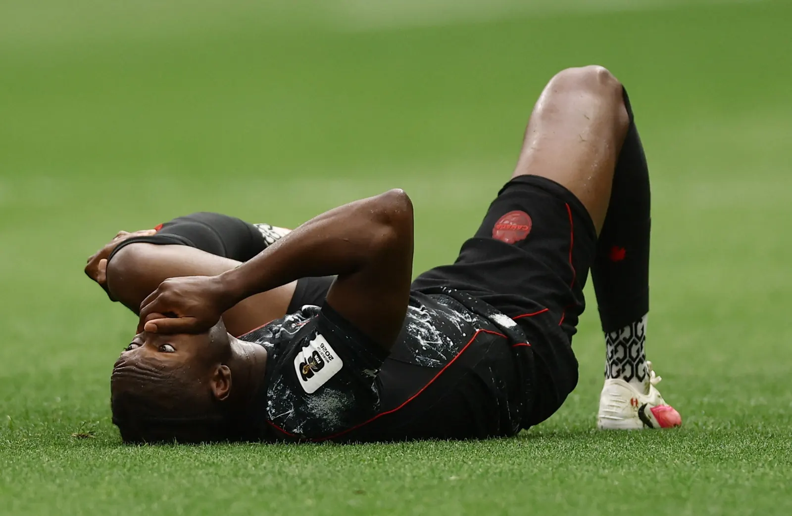Jogador do Canadá Ismaël Koné recebe atendimento médico após sofrer grave lesão em campo na Copa do Mundo 2026.