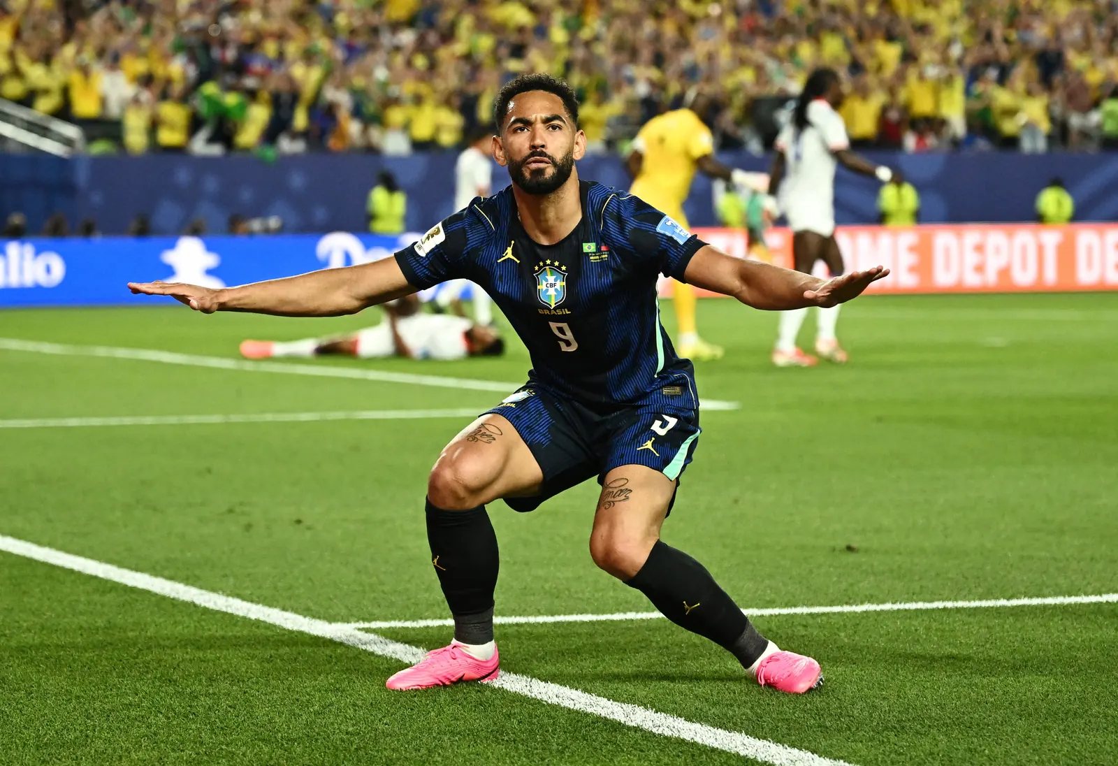 Jogador Matheus Cunha comemora um gol simulando surfar uma onda.