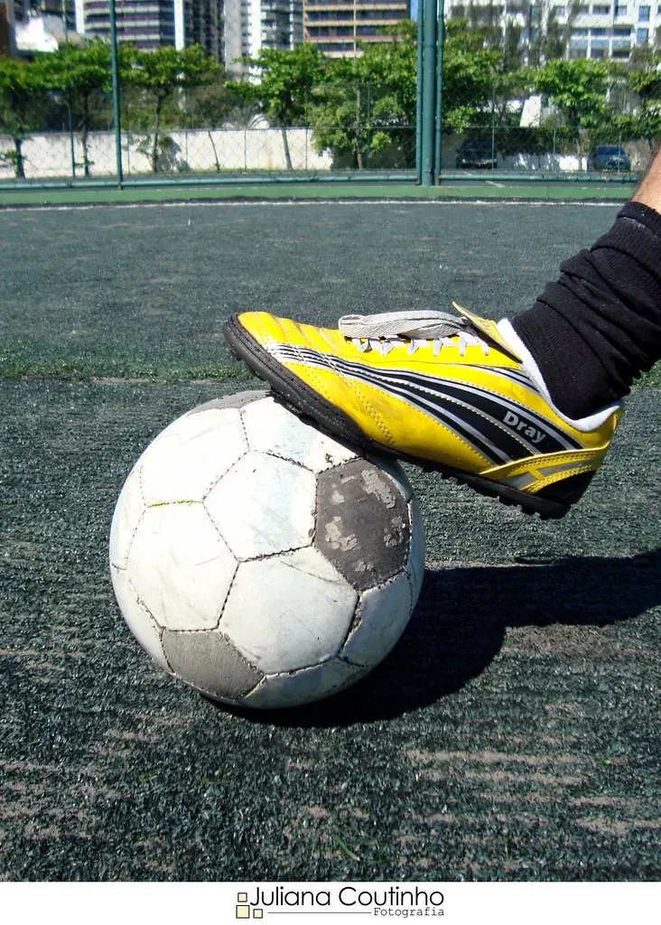 Jogador de futebol com chuteiras em campo