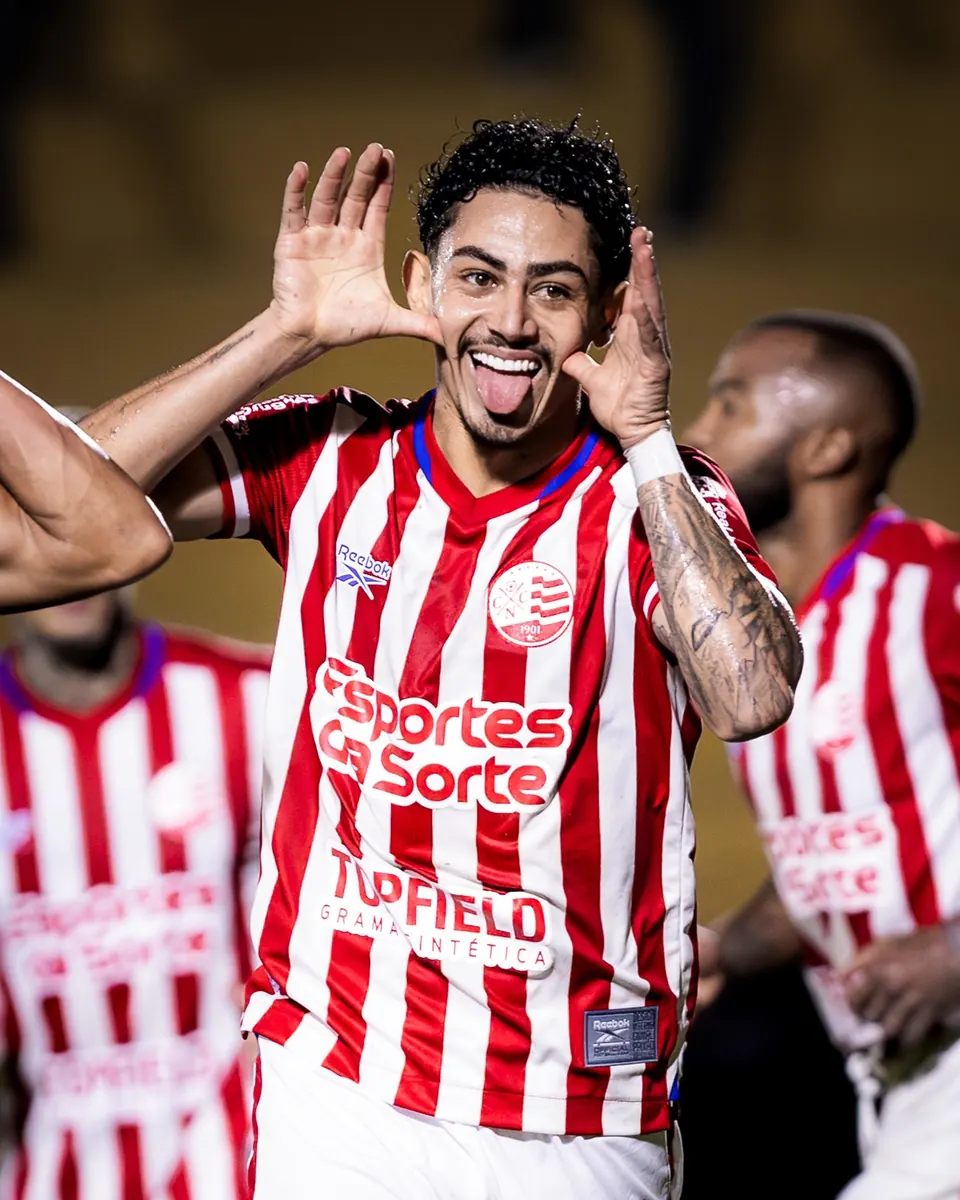 Jogador Dodô, do Náutico, comemora um gol em campo vestindo o uniforme do time.
