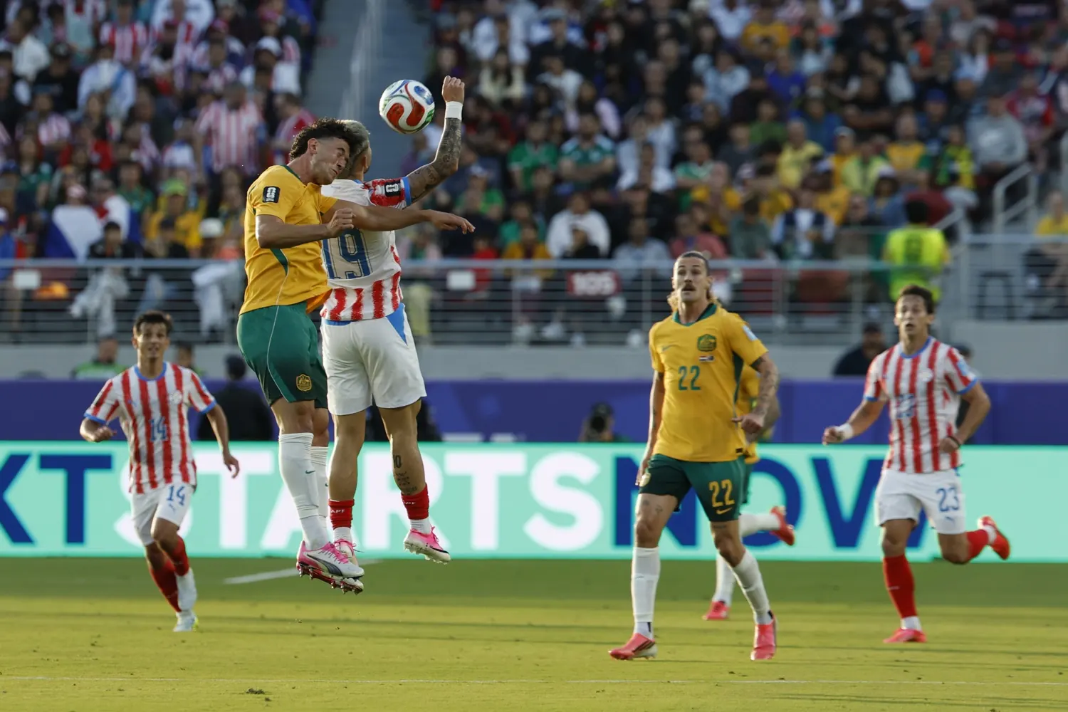 Jogadores da Austrália e Paraguai disputam a bola em partida da Copa do Mundo.