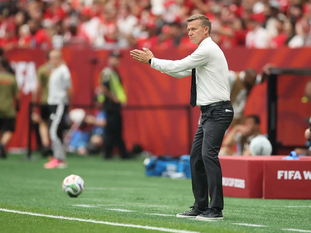 Técnico do Canadá, Jesse Marsch, com uniforme de treinamento, dá instruções em campo durante jogo da Copa do Mundo FIFA 2026.