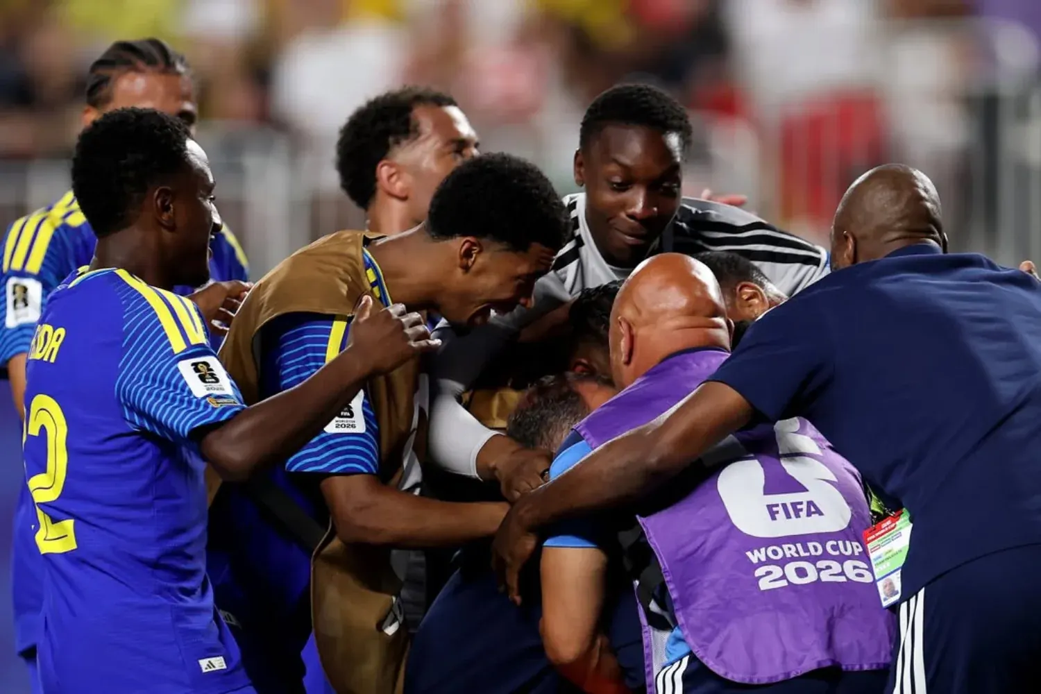 Jogadores da seleção de Curaçao comemorando um gol ou lance importante em uma partida de futebol.