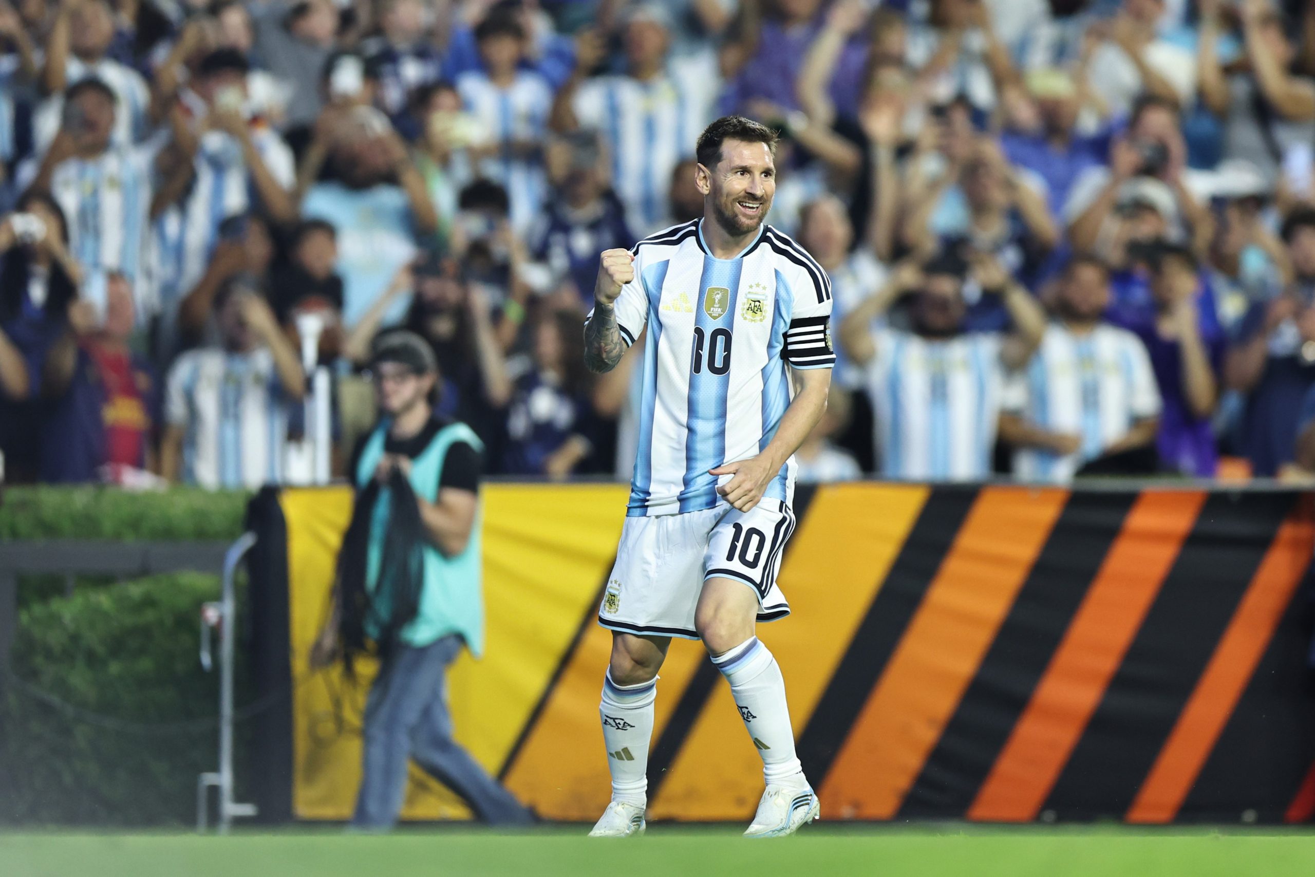 Lionel Messi comemora um gol pela seleção argentina em um campo de futebol.