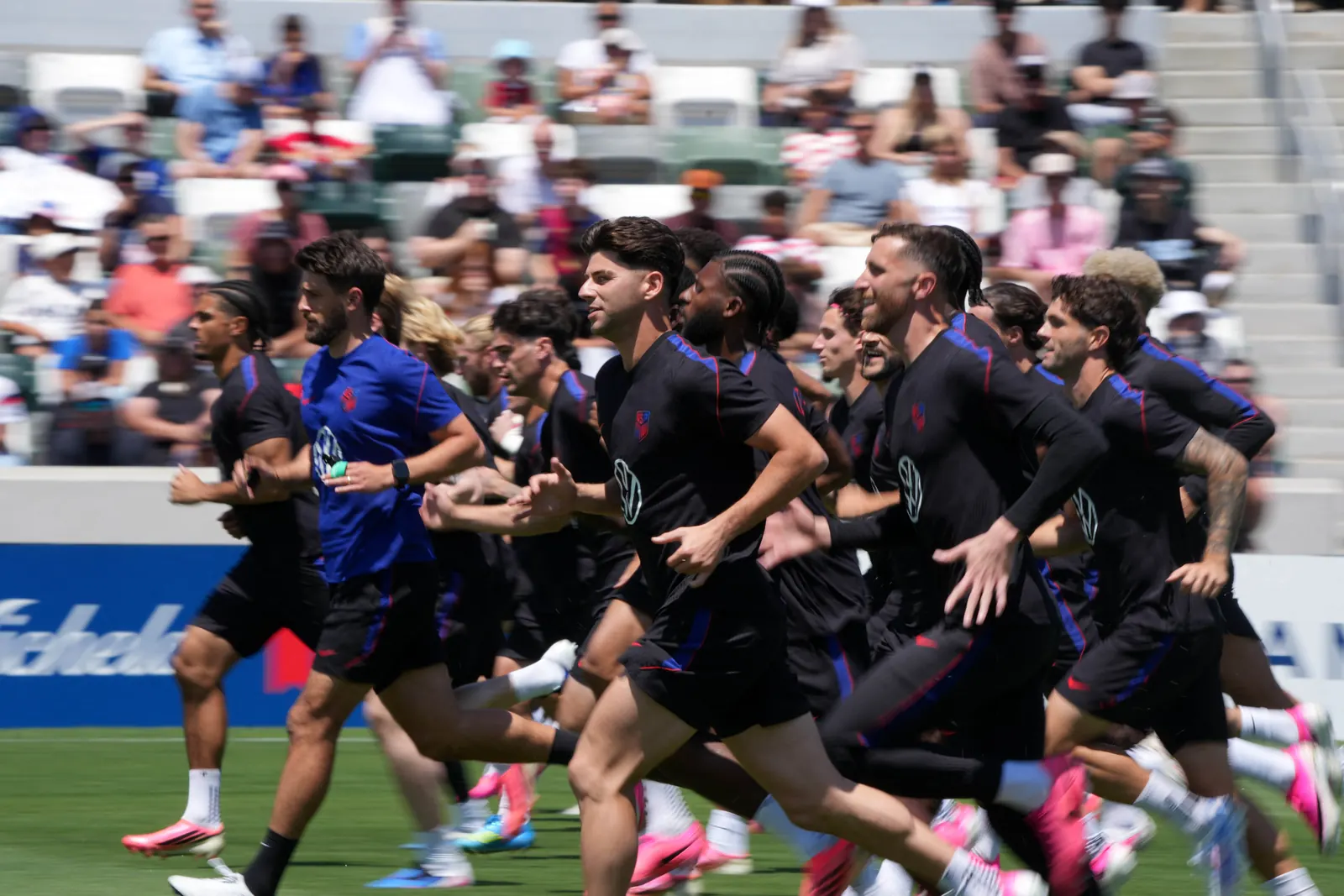 Jogadores da seleção dos Estados Unidos utilizando capacetes e equipamentos de monitoramento cerebral durante um treino de cobranças de pênalti.