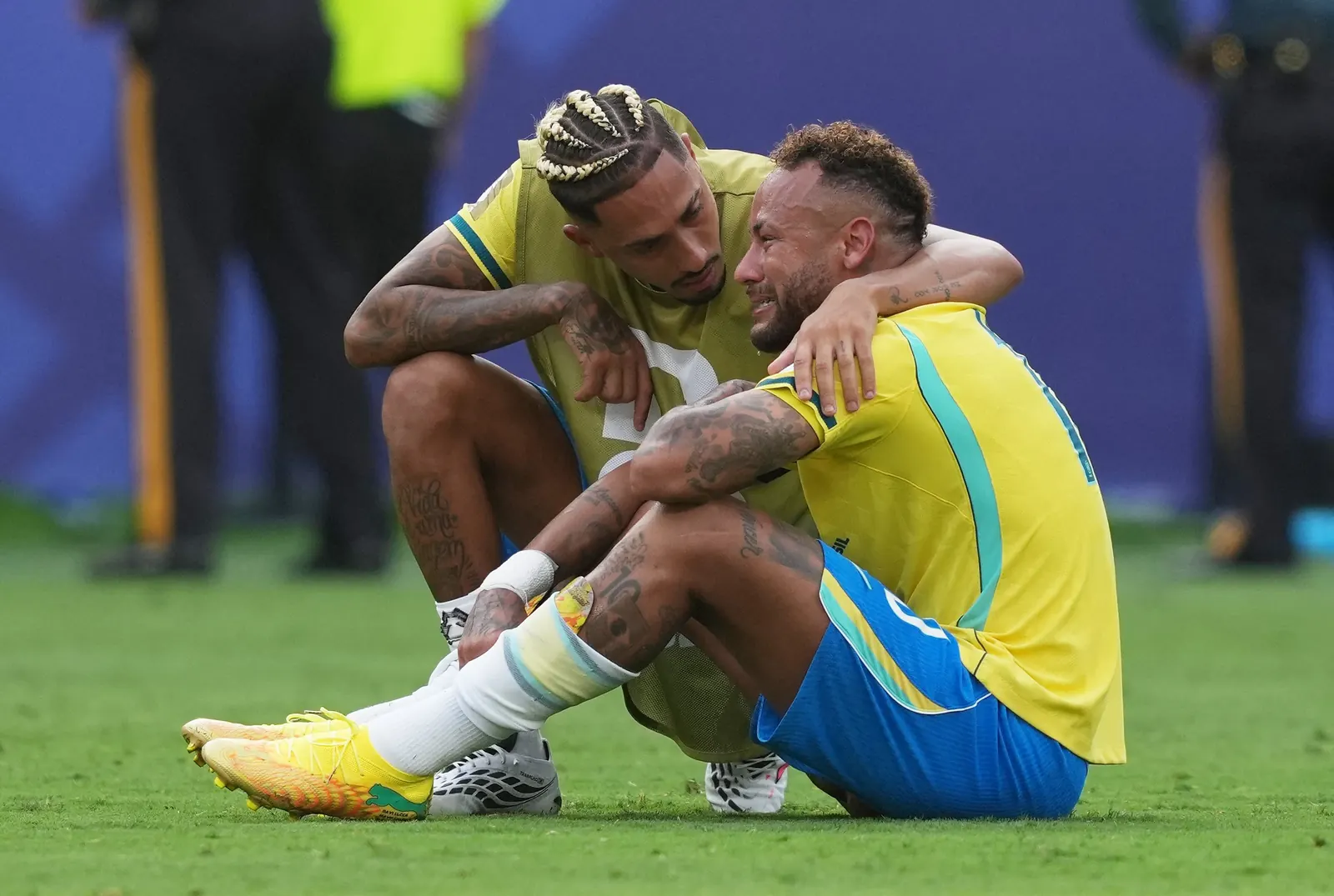 Neymar e Danilo consolam companheiros de equipe em campo após a derrota do Brasil na Copa do Mundo.