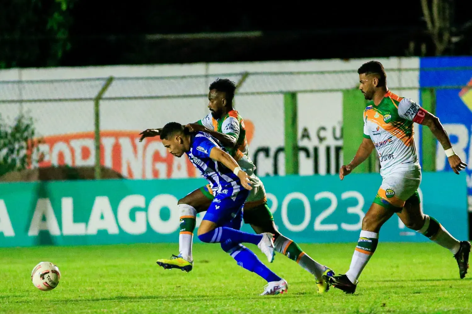 Jogadores do CSA em campo durante uma partida de futebol, com foco na tensão de uma possível disputa por pênaltis.