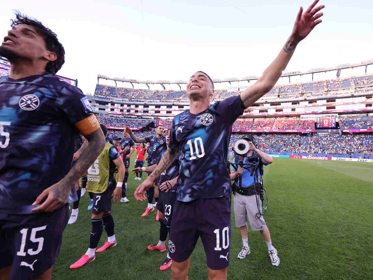 Miguel Almirón comemorando com a torcida paraguaia em um momento de celebração.