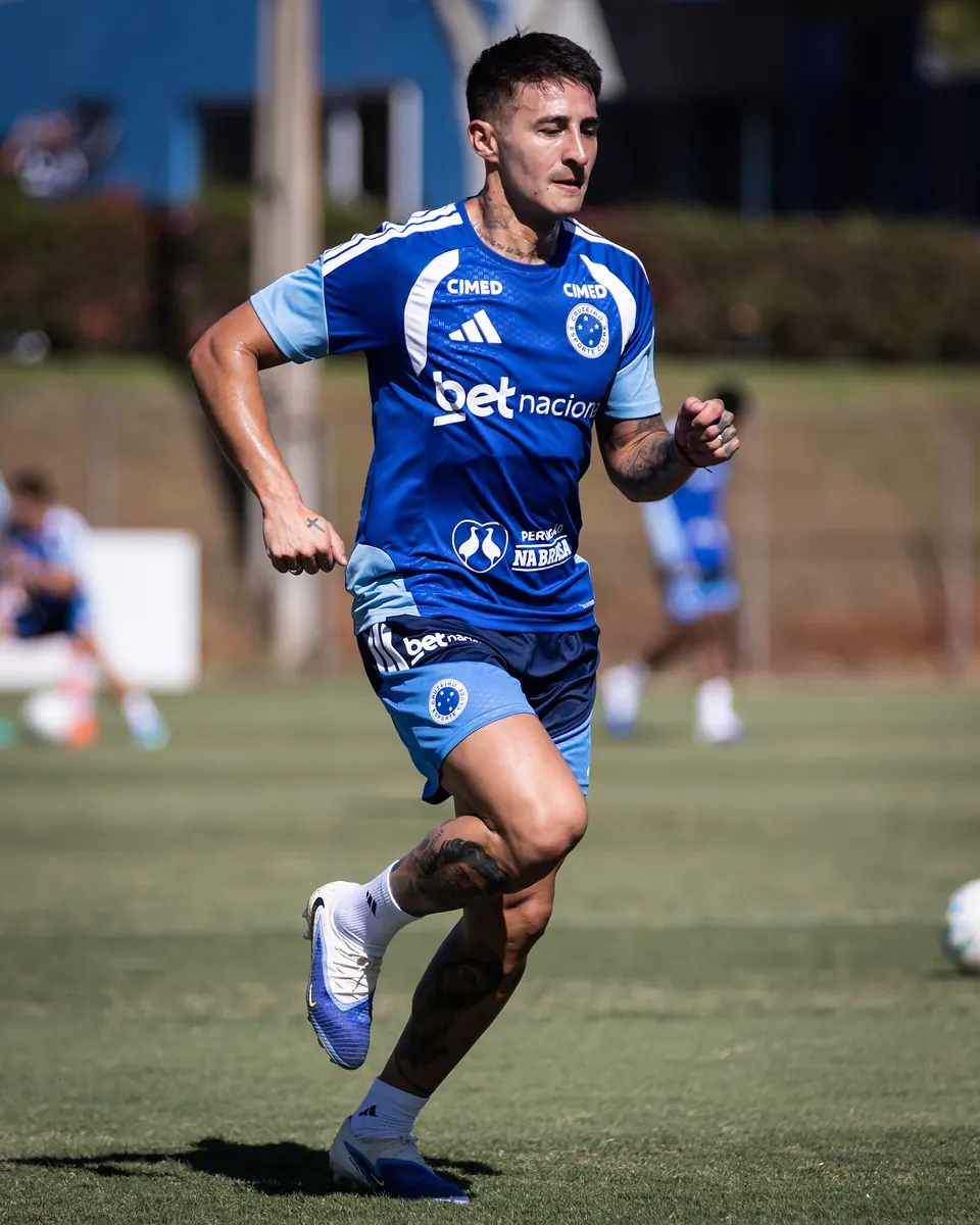 Grupo de jogadores estrangeiros do Cruzeiro em campo durante um treino.