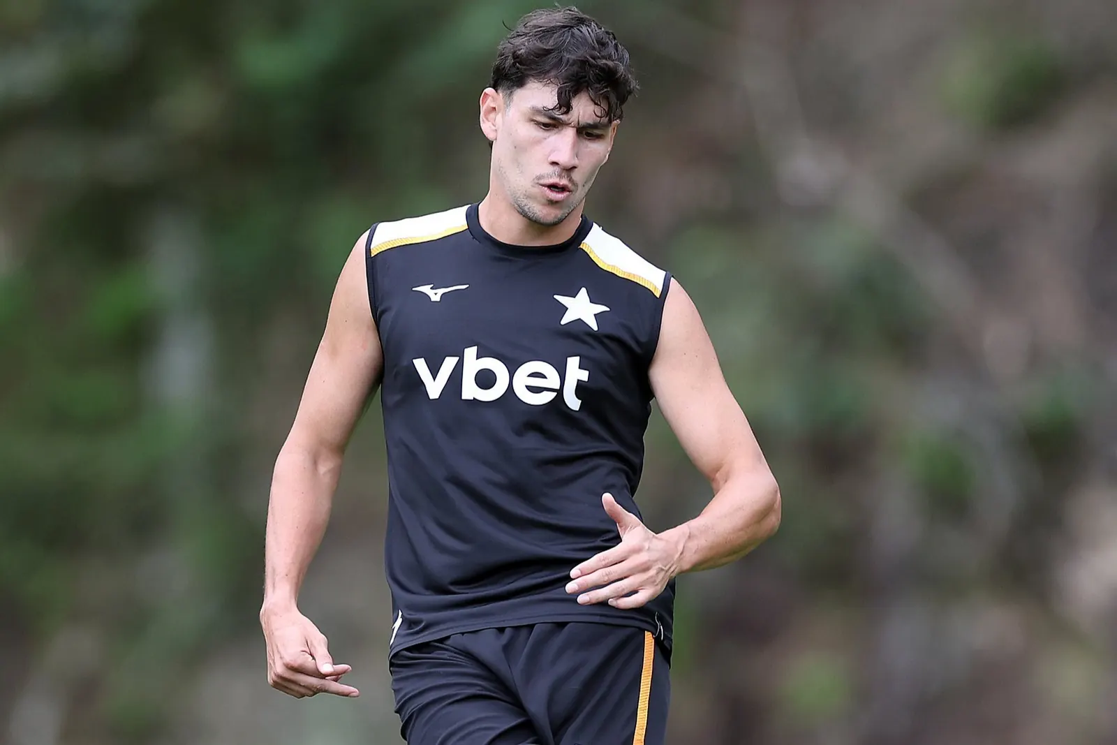 Zagueiro Ferraresi em treino do Botafogo, vestindo uniforme alvinegro, campo gramado ao fundo