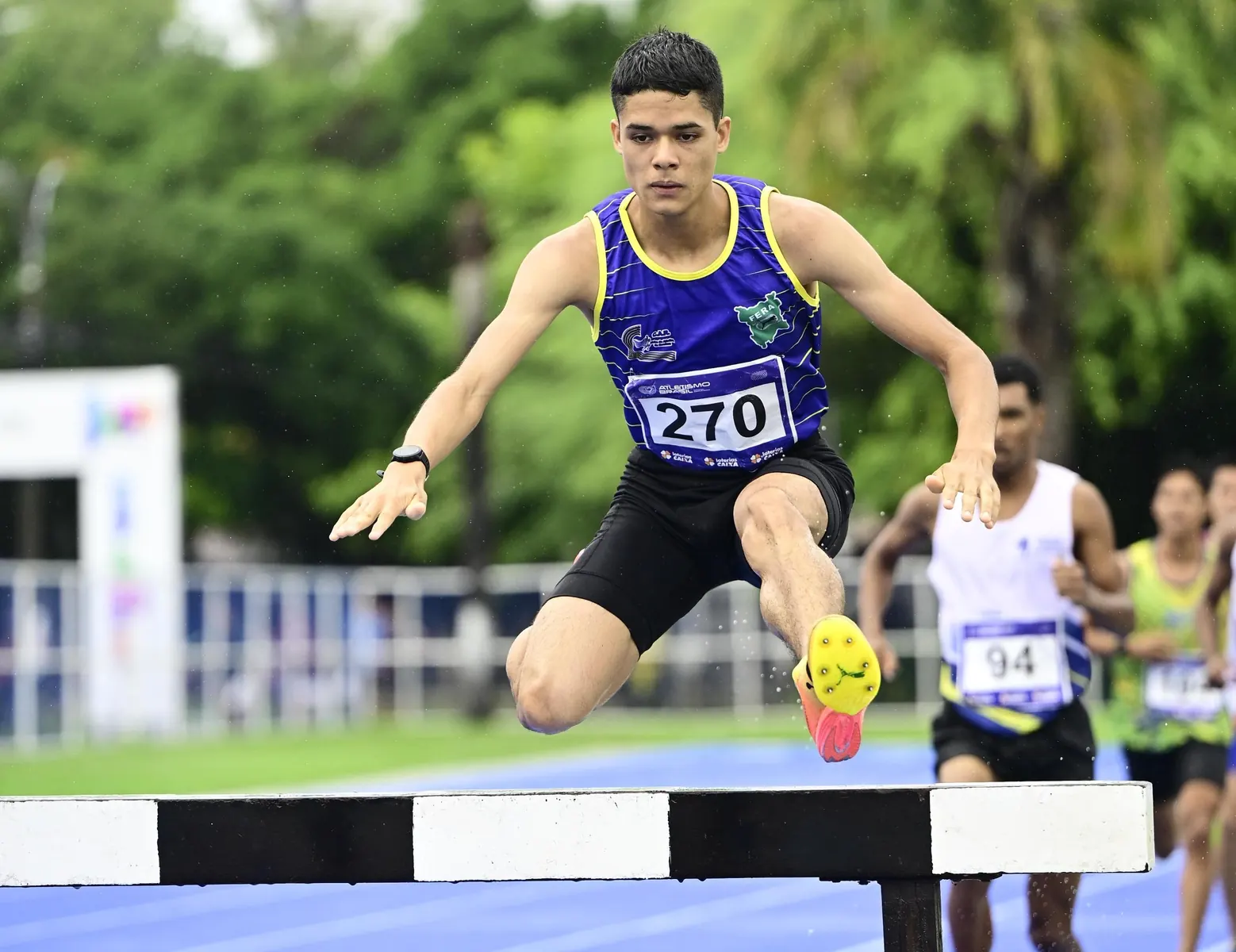 Enzo Watson correndo em uma pista de atletismo durante uma competição.