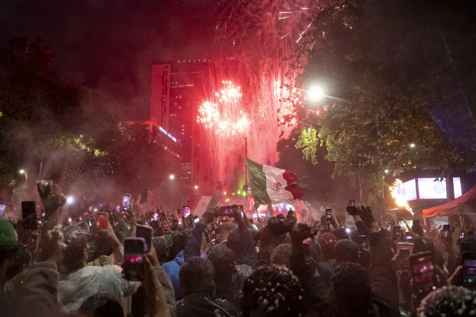 Torcedores mexicanos comemoram a classificação para as oitavas de final da Copa do Mundo com bandeiras e fogos.