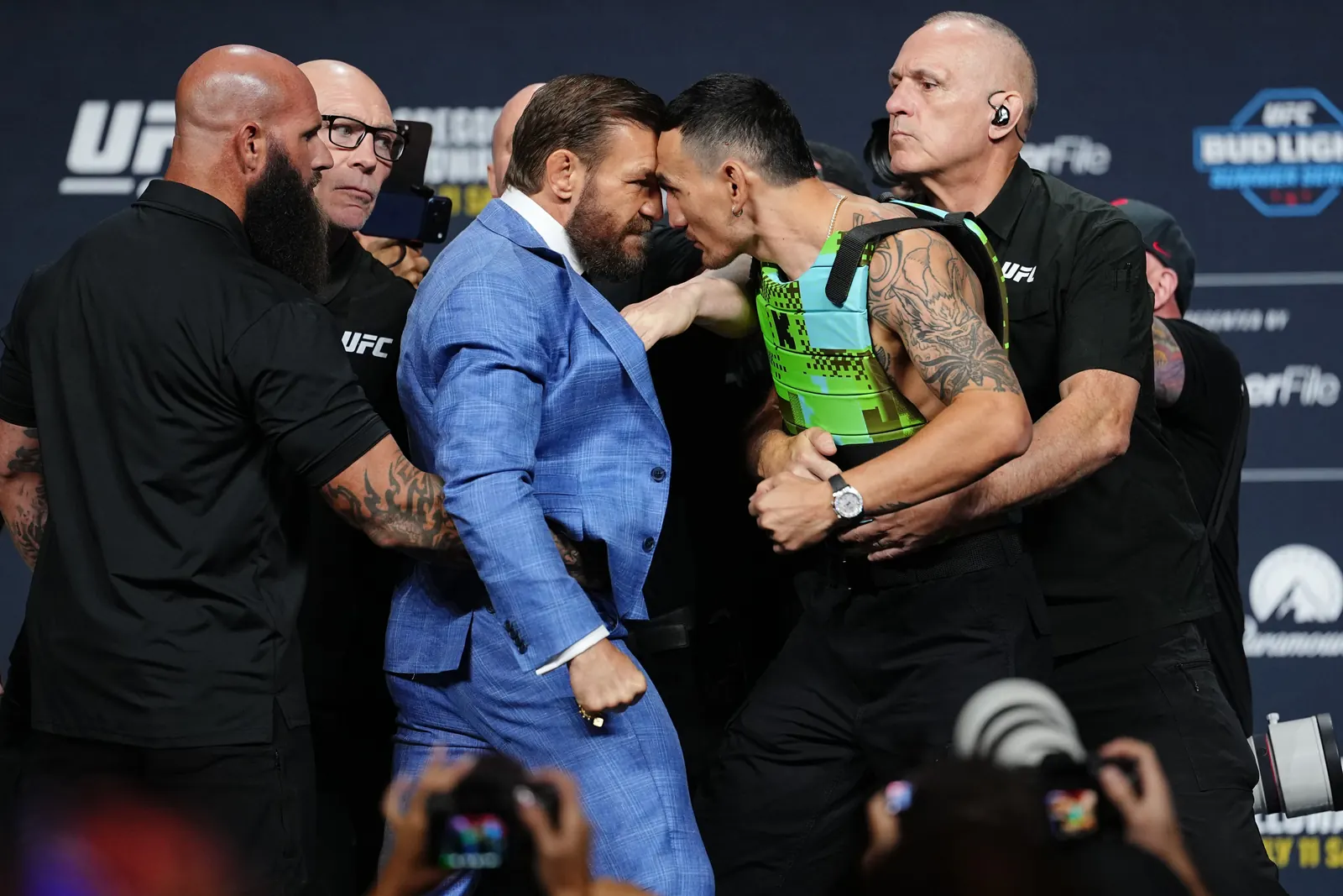 Conor McGregor e Max Holloway em encarada tensa durante a pesagem cerimonial do UFC 329 em Las Vegas.