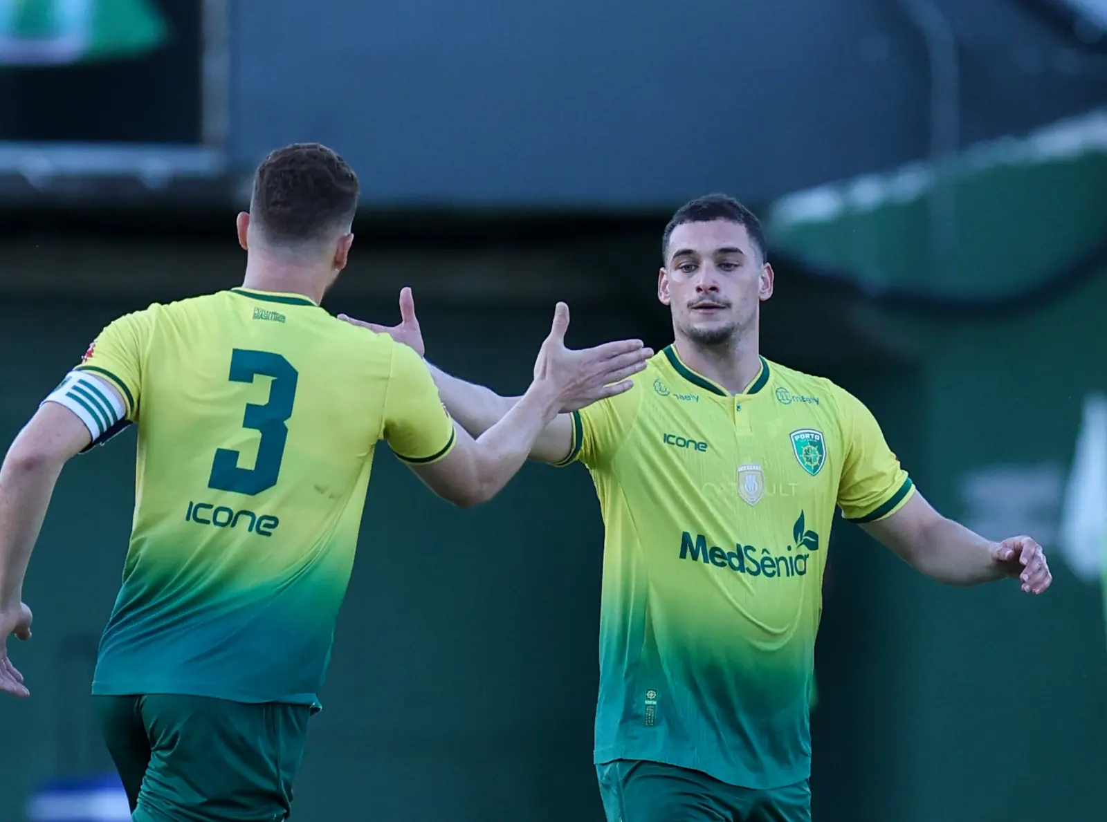 Jogador de futebol comemora um gol no gramado