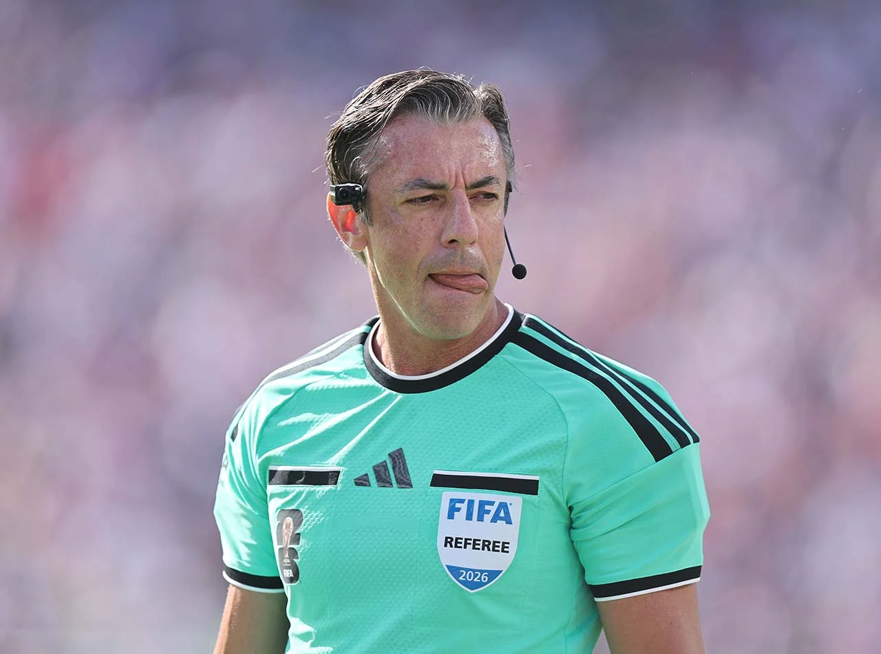 Imagem do árbitro Raphael Claus em campo, com foco em sua atuação em uma partida.