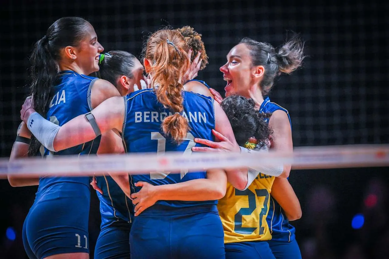 Jogadoras da seleção brasileira feminina de vôlei comemoram um ponto na final da Liga das Nações contra a Turquia, usando uniforme amarelo e azul