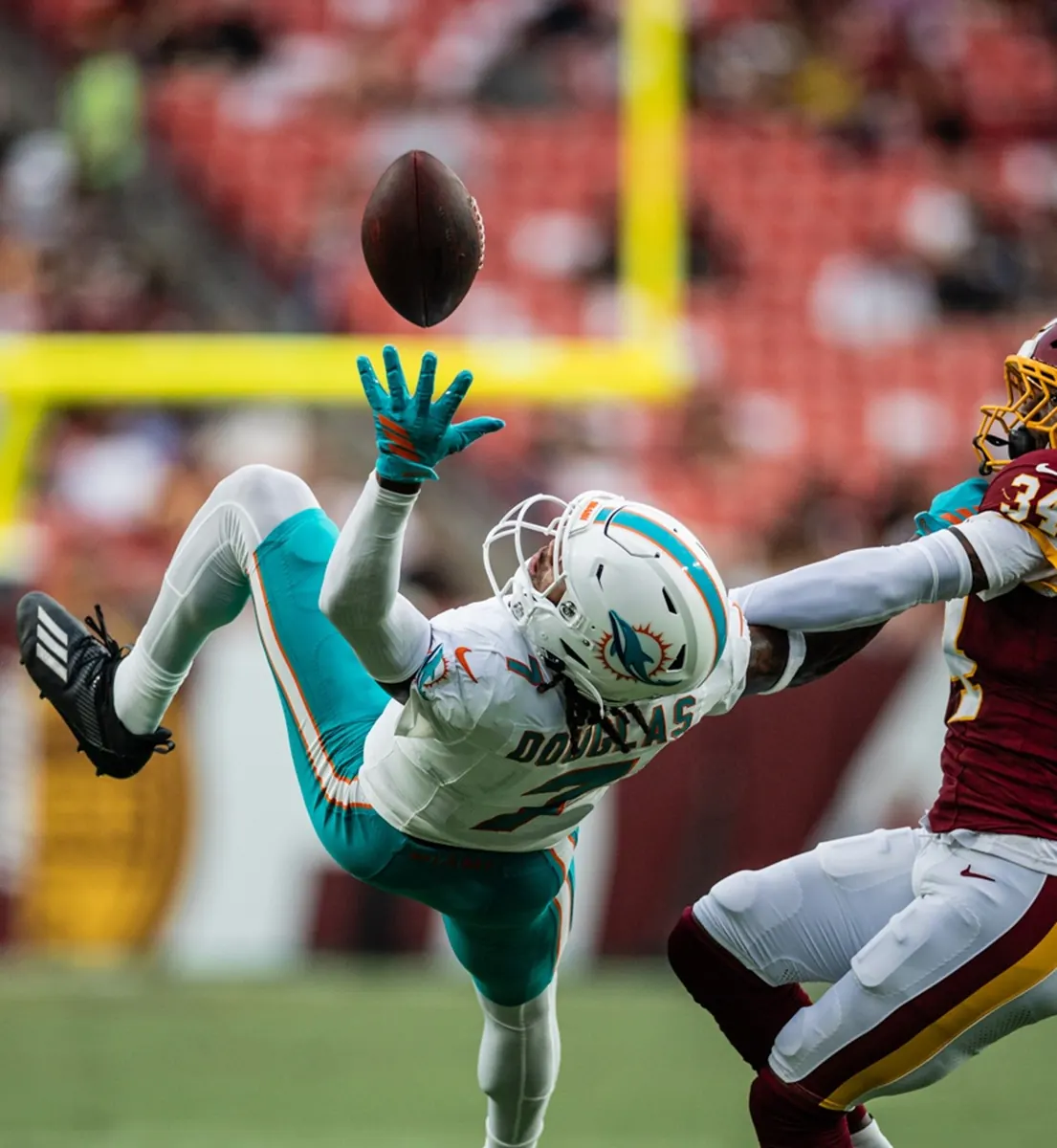 Caleb Douglas, wide receiver do Miami Dolphins, faz recepção de uma mão durante jogo contra o Washington Commanders na pré-temporada da NFL.